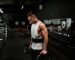 man in white tank top holding bumper plate