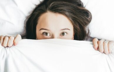 woman covering her face with blanket